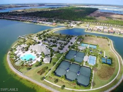Aerial view of property and surrounding area featuring a nearby body of water and a pool