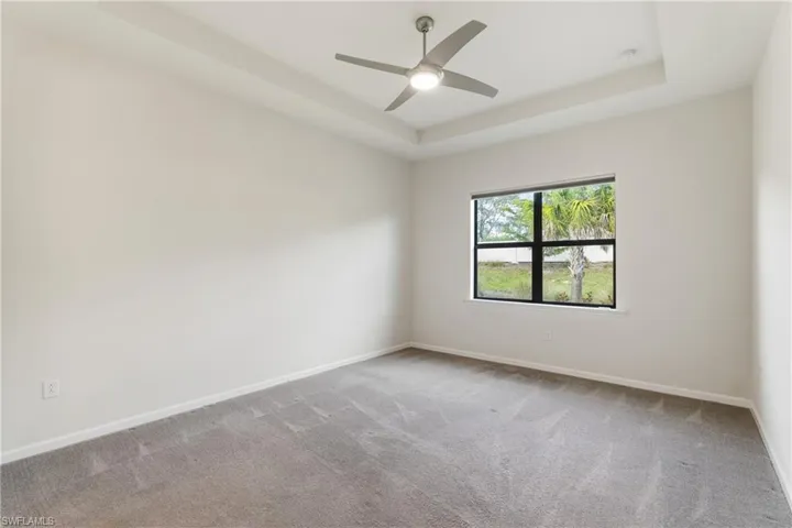 Primary bedroom featuring tray ceiling detail