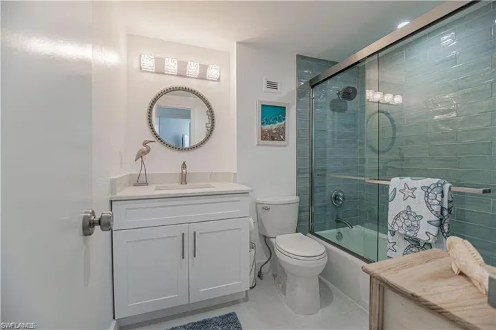 Full bathroom featuring vanity, bath / shower combo with glass door, and light tile patterned floors