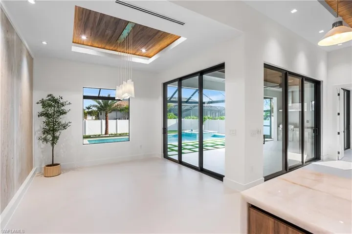 TINTED SLIDING DOORS leading to SCREENED LANAI & large PICTURE WINDOW offer views of POOL/SPA