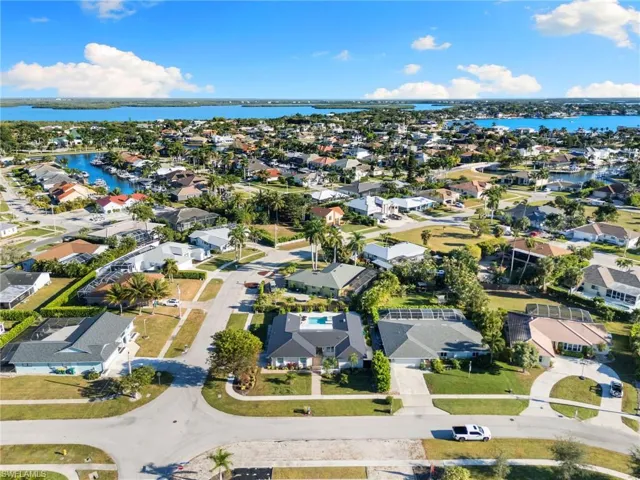 Aerial view of property and surrounding area with nearby suburban area and a large body of water