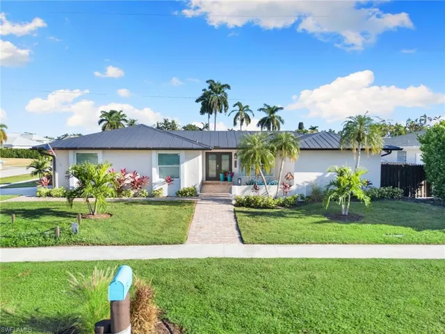 Ranch-style home with a metal roof and stucco siding