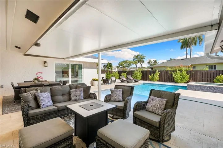Fenced backyard featuring a patio area, an outdoor living space, and a pool with connected hot tub