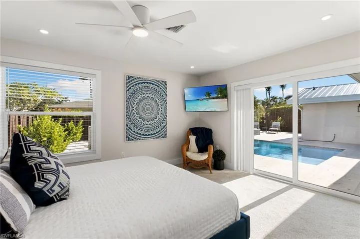 Carpeted bedroom featuring access to exterior, ceiling fan, and a sunroom