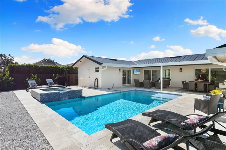 View of swimming pool featuring outdoor lounge area, a patio, a fenced backyard, a pool with connected hot tub, and outdoor dining space