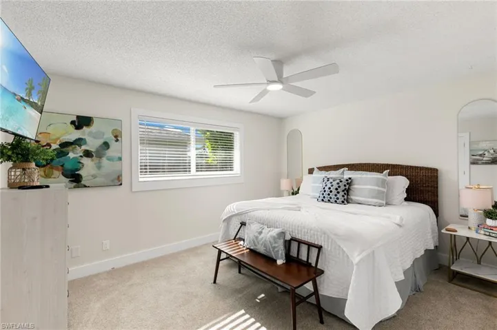 Bedroom featuring carpet floors, a textured ceiling, and ceiling fan