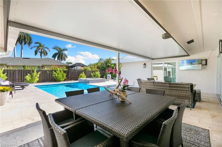 View of swimming pool featuring a patio, outdoor dining area, a fenced backyard, and a pool with connected hot tub