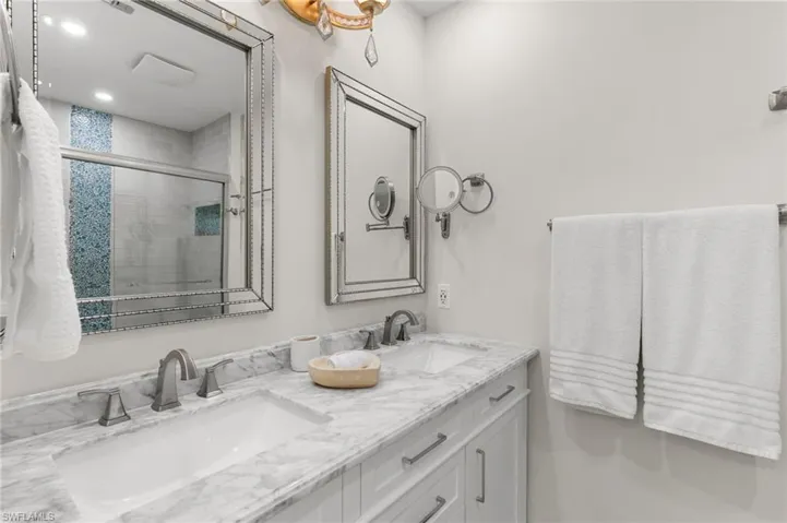 Full bath featuring a stall shower and double vanity
