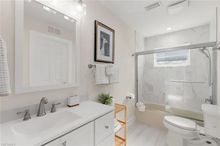 Full bath with vanity and shower / bath combination with glass door