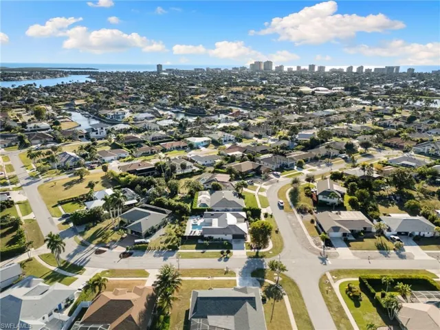 Aerial view of property and surrounding area featuring a nearby body of water and nearby suburban area