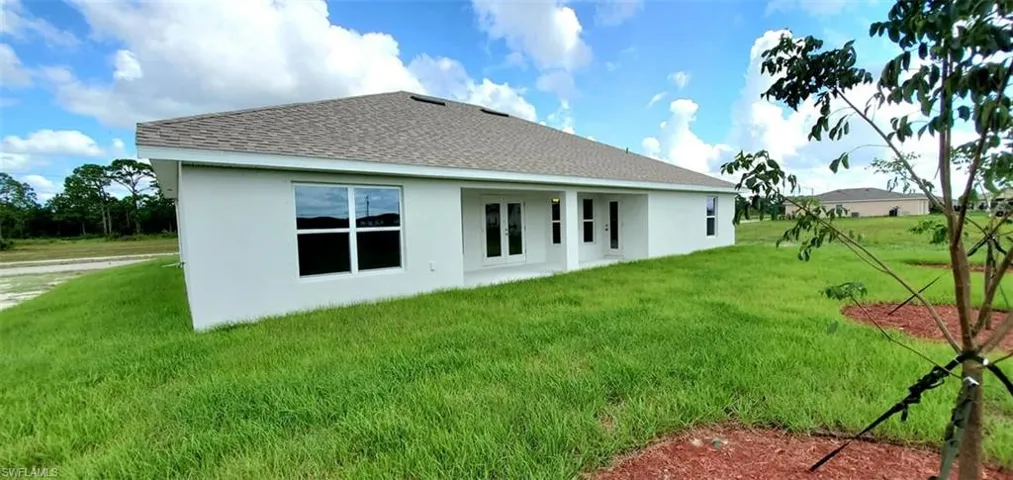Rear view of property with a yard