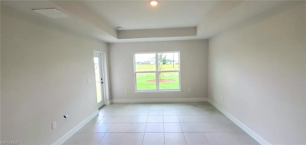 Tiled Primary bedroom featuring a tray ceiling