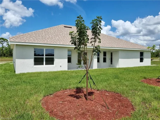 Rear view of house featuring a yard