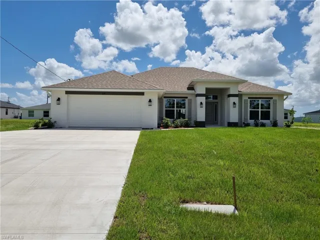 View of front of home featuring a front yard and a garage