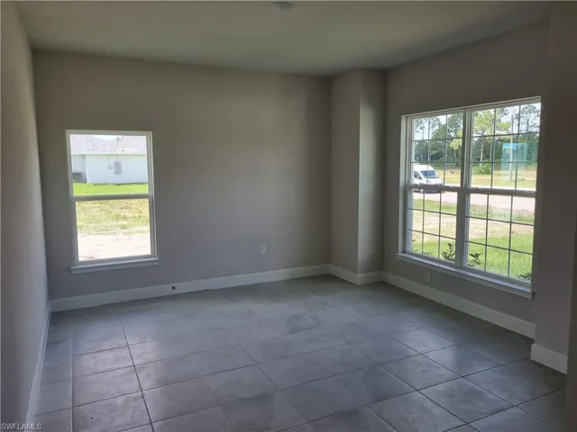 Empty room with a healthy amount of sunlight and tile patterned floors