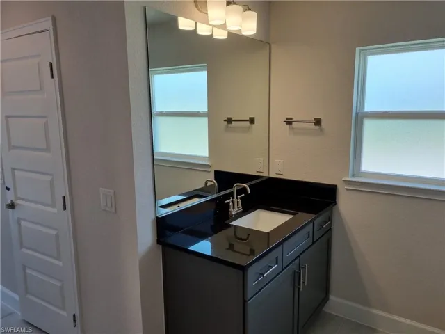 Bathroom with tile patterned floors, a healthy amount of sunlight, and vanity