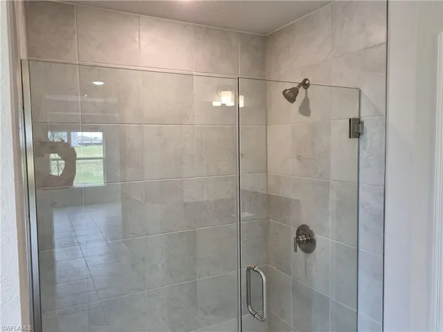 Details featuring a textured ceiling and an enclosed shower