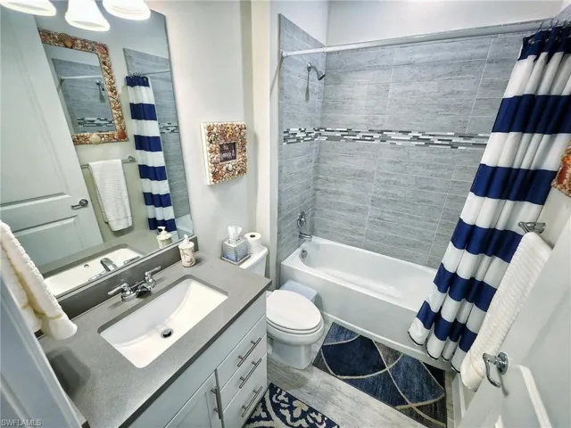2nd bathroom with toilet, vanity, and shower / bath combo