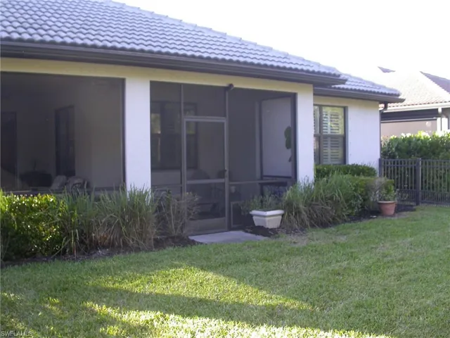 Rear view of property featuring a yard and a sunroom
