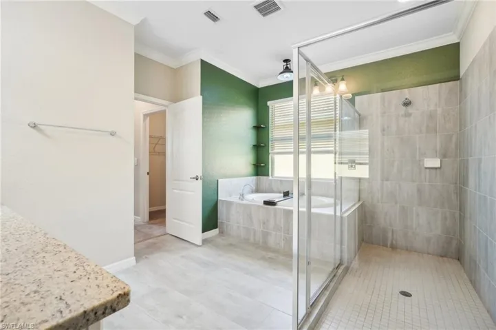Bathroom featuring tile flooring, separate shower and tub, and Crown molding
