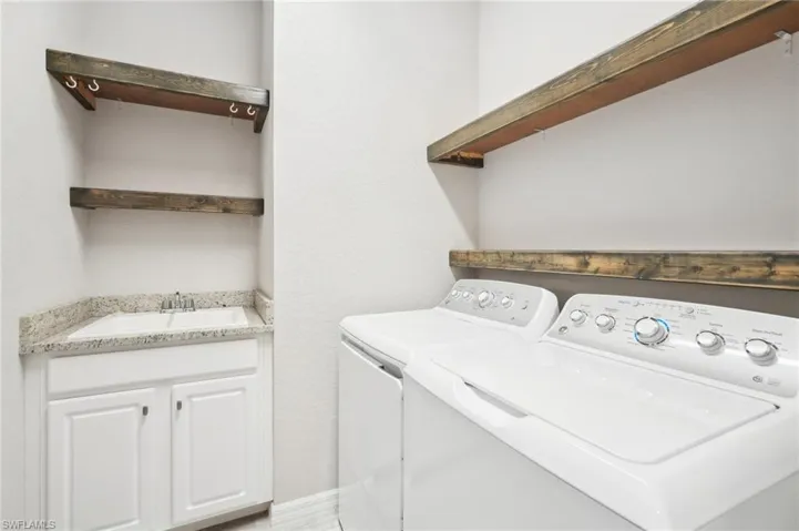 Clothes washing area with sink and washer and dryer