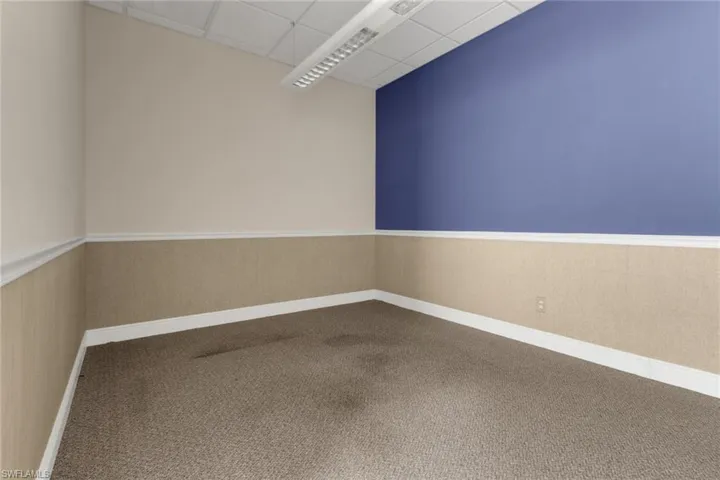 Carpeted empty room with a drop ceiling