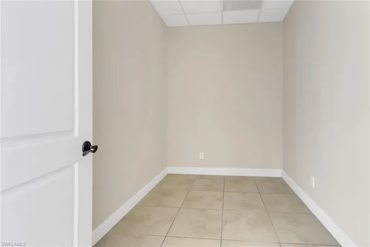 Spare room with a drop ceiling and light tile patterned floors