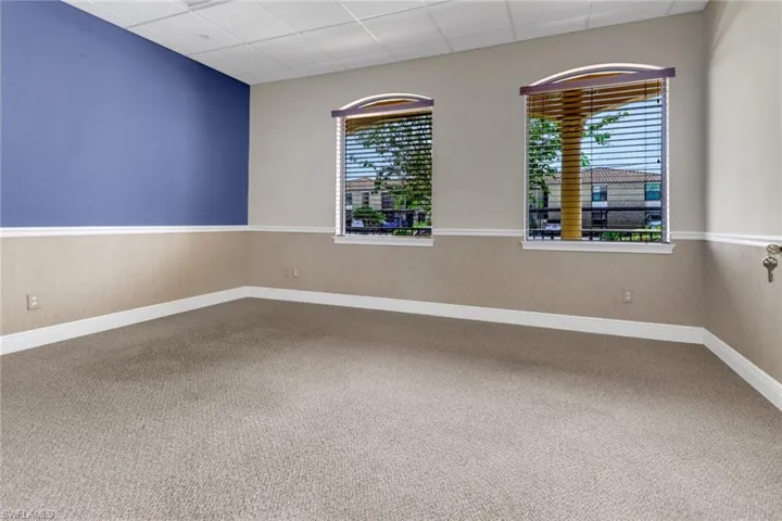 Carpeted empty room featuring a drop ceiling