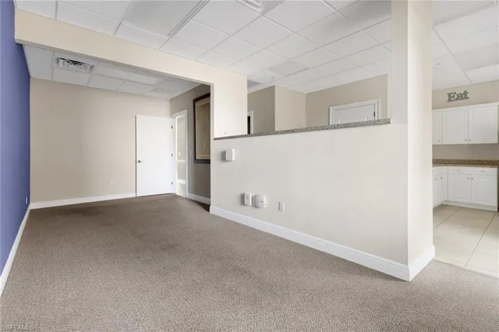 Basement featuring a paneled ceiling and light colored carpet