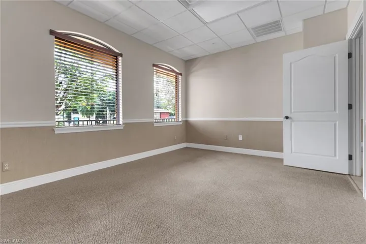Carpeted spare room with a drop ceiling