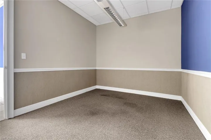 Unfurnished room with a paneled ceiling and carpet floors