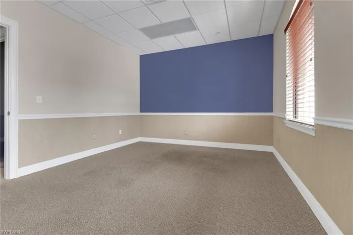 Unfurnished room with a paneled ceiling and carpet