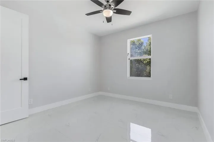 Spare room featuring ceiling fan and light tile floors