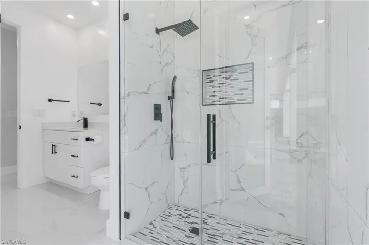 Bathroom featuring tile flooring, an enclosed shower, toilet, and vanity