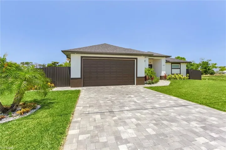 View of front of house with a garage and a front lawn