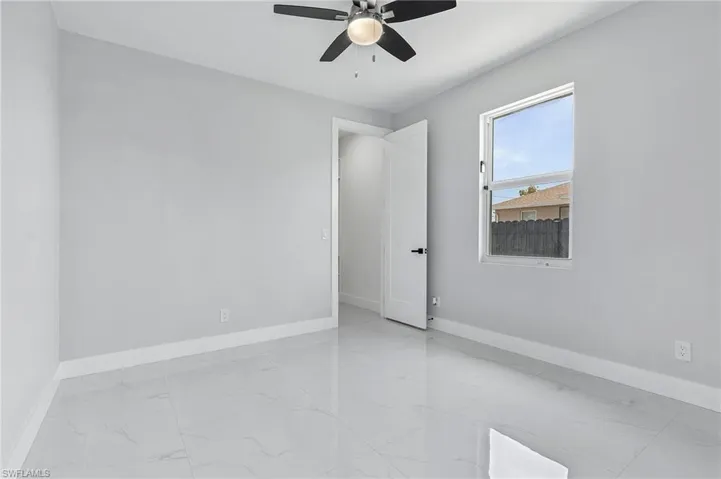 Empty room featuring ceiling fan and light tile flooring