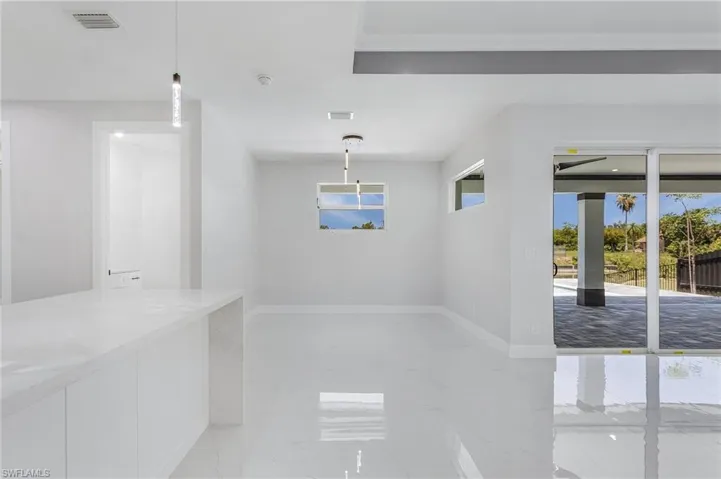 Hallway with a wealth of natural light and light tile floors