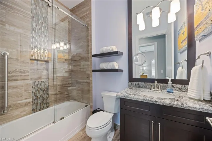 Full bath with bath / shower combo with glass door and vanity