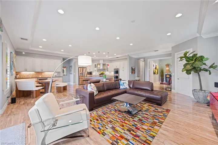 Living room with ornamental molding, large format Porcelain Tile flooring, and recessed lighting