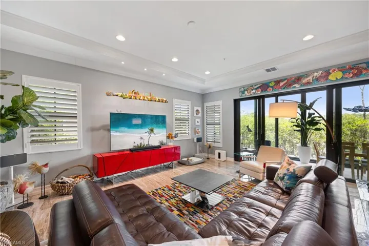 Living area with large format Porcelain Tile 12x24 finished floors, recessed lighting, and ornamental molding