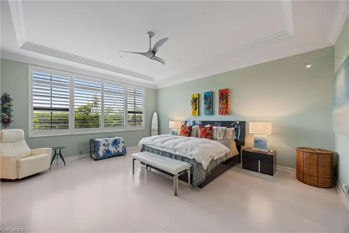 Bedroom featuring a tray ceiling, ornamental molding, ceiling fan, and Custom maple wood finished floors!