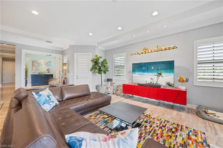 Living room featuring large format 12x24 Porcelain Tile flooring, crown molding, and recessed lighting