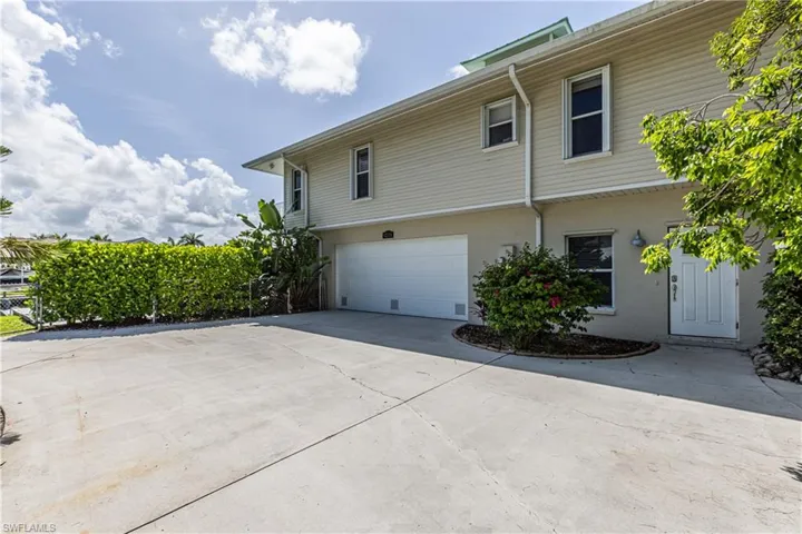 View of side of home with an attached garage and concrete driveway
