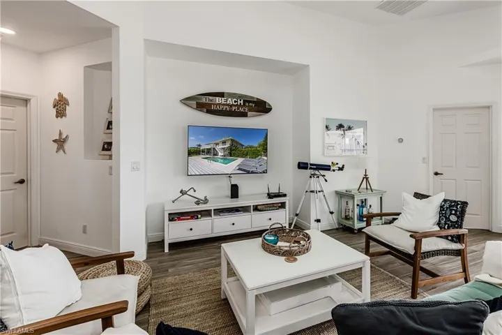 Living room with dark wood-type flooring and baseboards