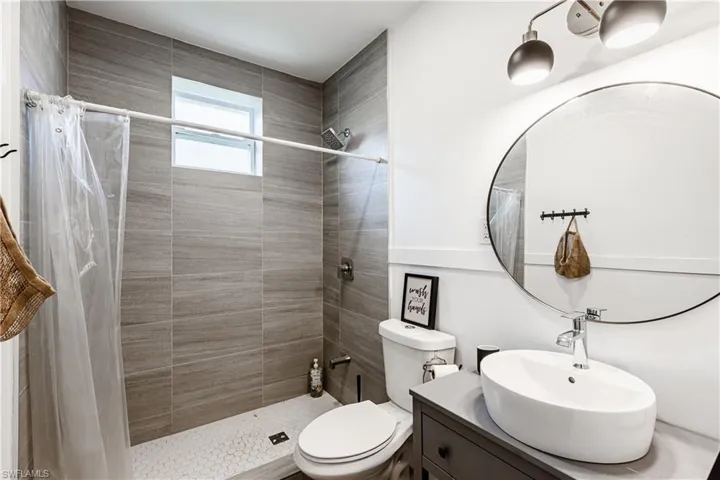 Bathroom with vanity and tiled shower
