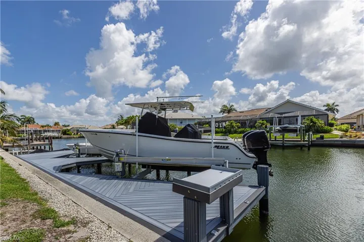 Dock area featuring boat lift and a water view