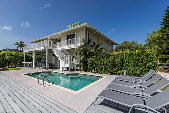 View of pool with stairway, a patio, and a wooden deck