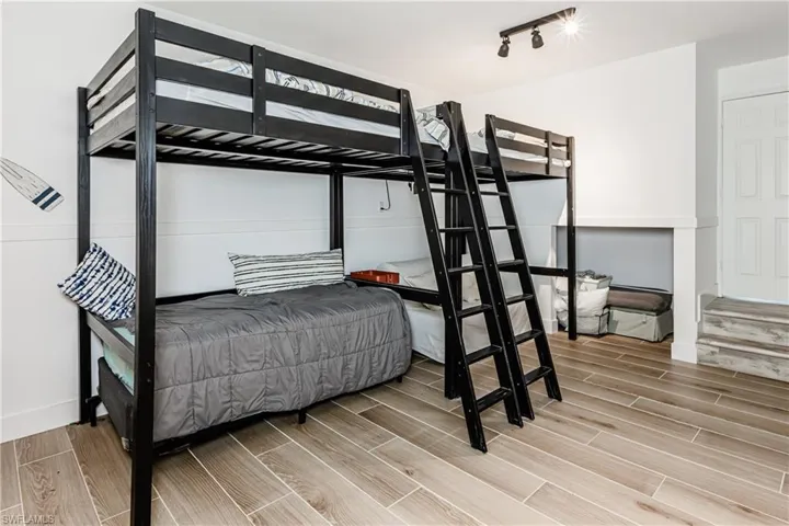 Bedroom with wood finished floors and track lighting