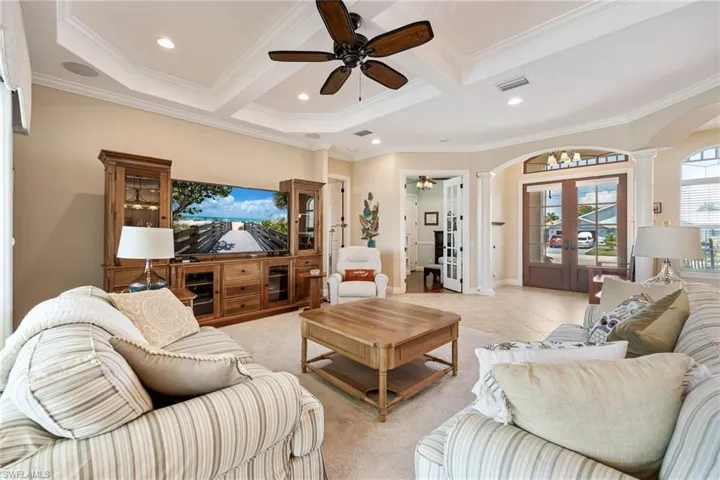 living room with view of the foyer, den, and door to primary bedroom