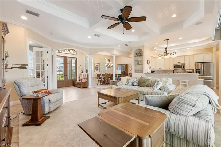 living room with view of the kitchen, dining room, foyer, and den